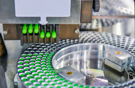 Green capsule medicine pill production line, Industrial pharmaceutical concept.